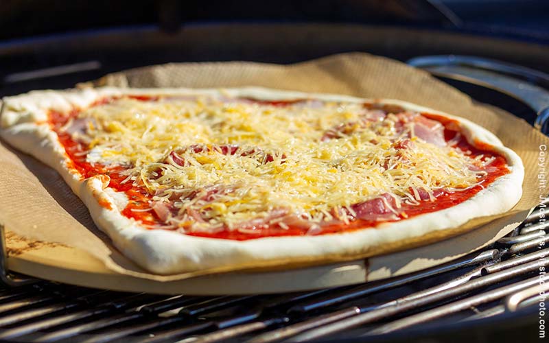 Zubereitung von Pizza auf dem Pizzastein im Gasgrill